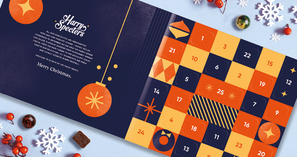 A luxury chocolate advent calendar surrounded by Christmas decorations