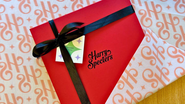 A premium chocolate box tied with a black ribbon wrapped in Harry Specters tissue paper and featuring a thank you card