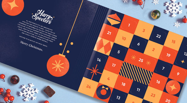 A luxury chocolate advent calendar surrounded by Christmas decorations