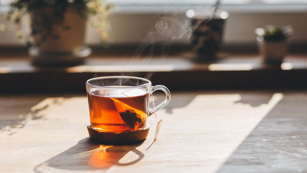 A mug of tea brewing on a wooden table