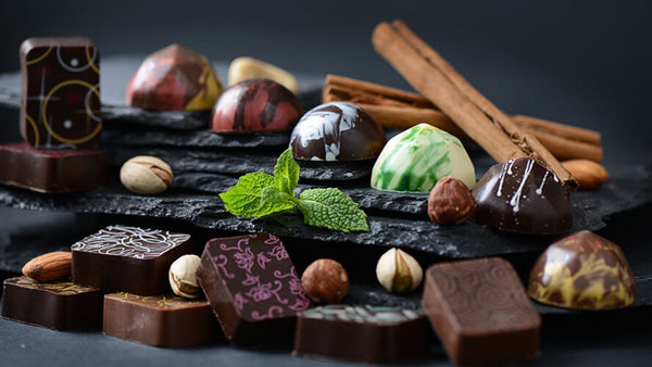 Hand-decorated luxury chocolates on slate with fresh ingredients 