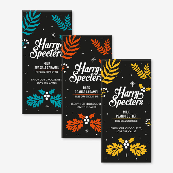 Three chocolate bars including dark vegan orange, sea salt caramel, and peanut butter flavours in festive Christmas packaging