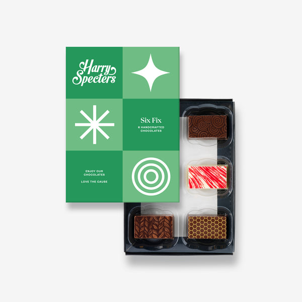 A box of 6 artisan chocolates partially covered by a box lid featuring the name Harry Specters