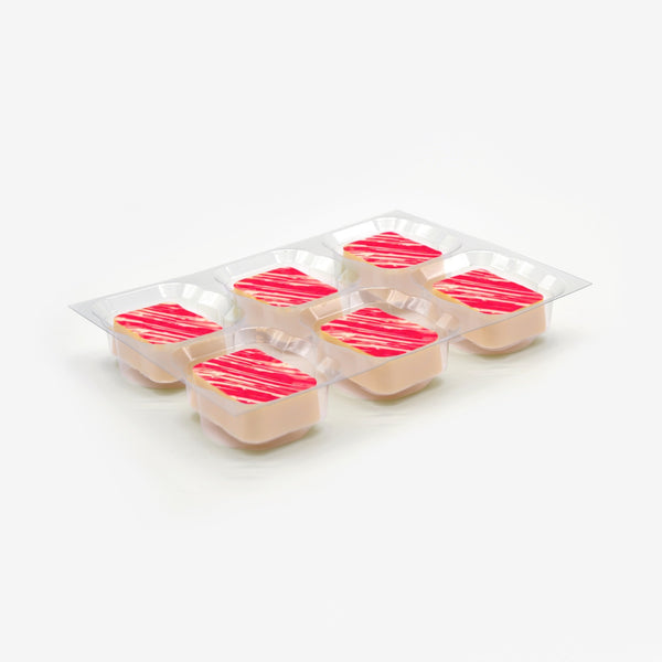 A tray of white strawberry cheesecake chocolates in a clear plastic tray